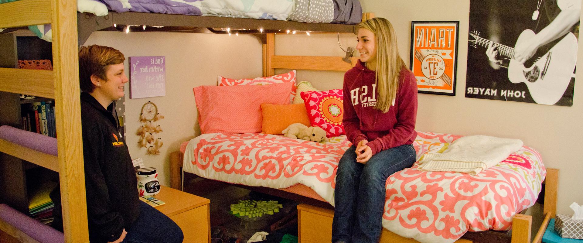 photo of two students conversing in a dorm room